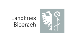 Das Logo des Landkreis Biberach. links ist der schwarze Schriftzug Landkreis Biberach auf weißem Grund zu sehen. Rechts davon auf grauem quadratischem Grund, in weiß in der linken Hälfte ein Adler und in der rechten Hälfte ein Bischofsstab.